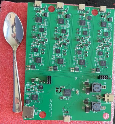 The green lab production board photographed next to a spoon for scale